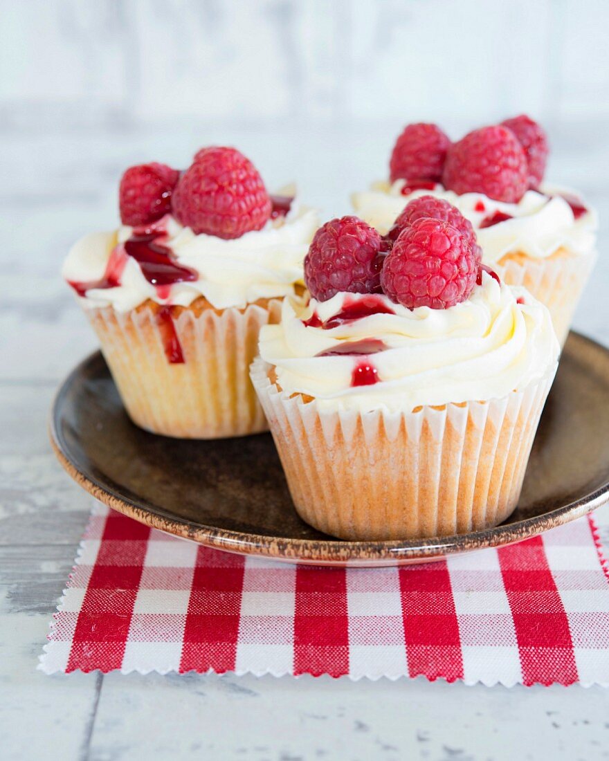 Cupcakes with cream frosting and raspberries