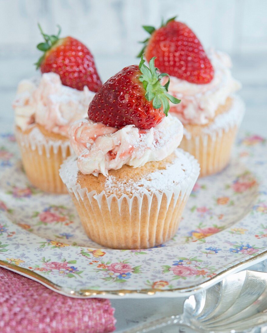 Cupcakes with strawberry cream and topped with a fresh strawberry