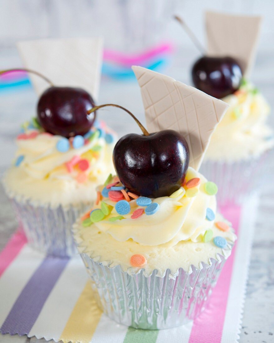 Cupcakes with sugar confetti and a cherry