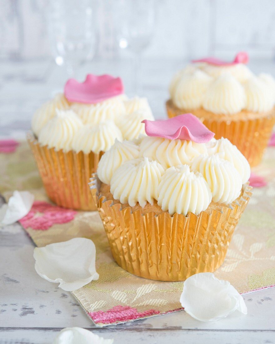 Cupcakes mit Buttercreme und Blütenblättern