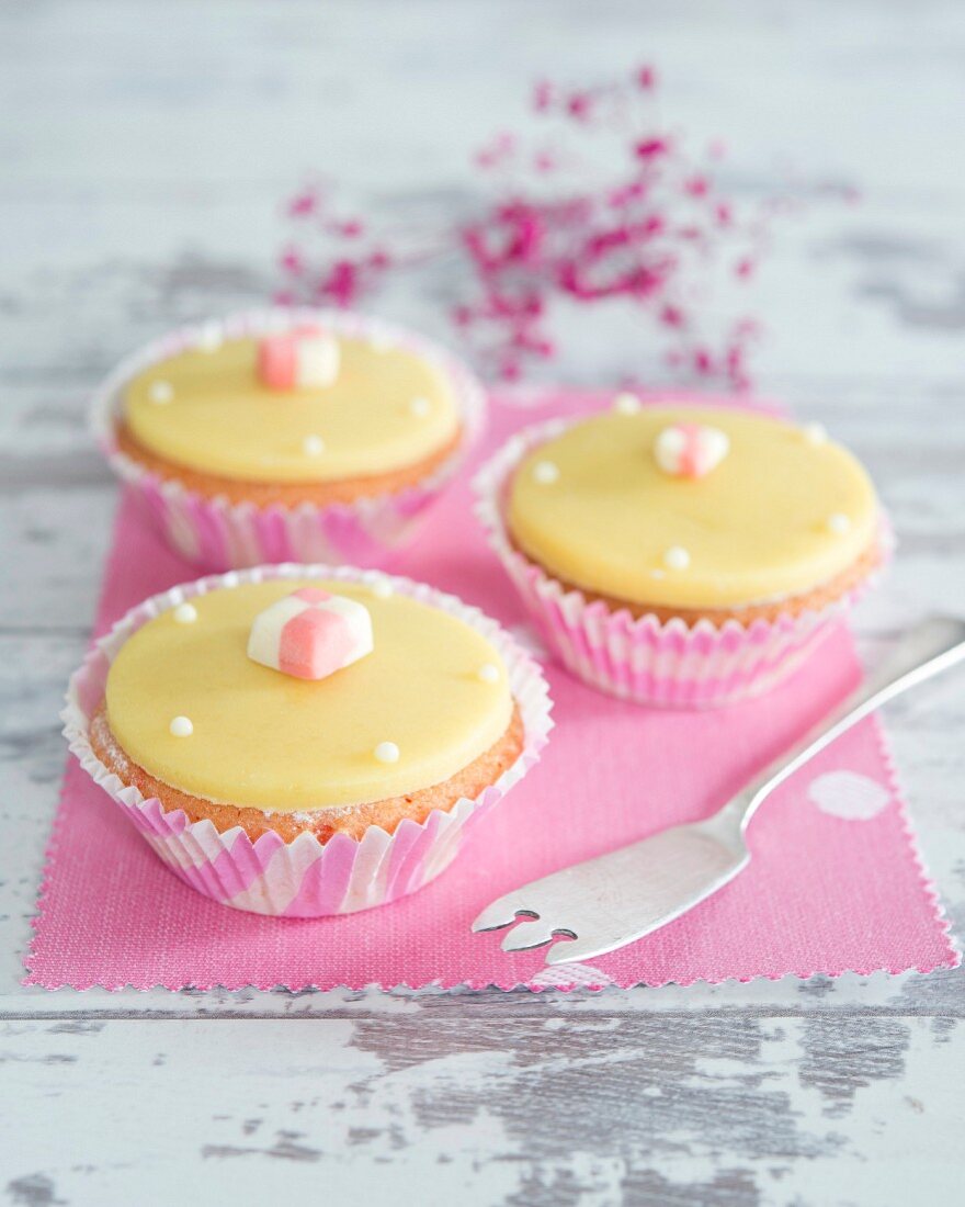 Cupcakes with yellow fondant icing and cubes