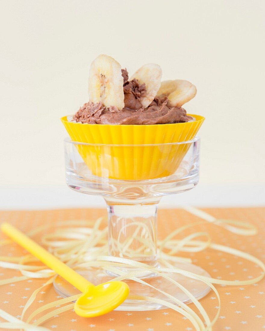 A chocolate cupcake with sliced banana on the top