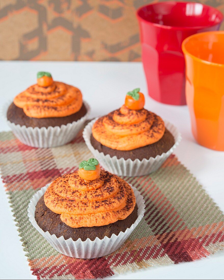 Chocolate cupcakes with pumpkin cream and marzipan pumpkins