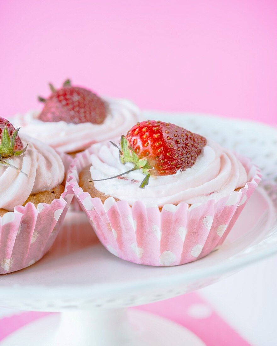 Cupcakes with strawberry frosting and a fresh strawberry