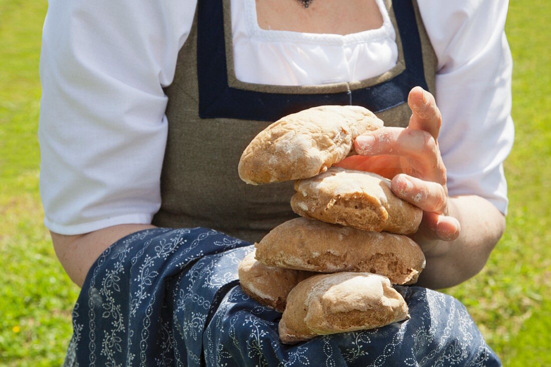 A woman holding freshly baked bread