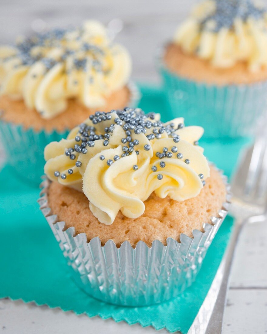 Cupcake mit Buttercreme und blauen Zuckerperlen
