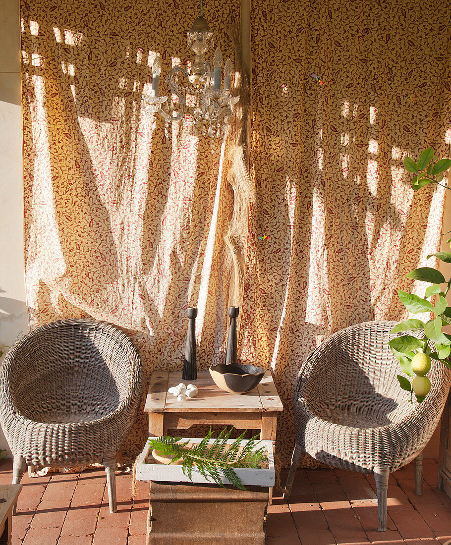 Two weathered wicker chairs in sunny seating area