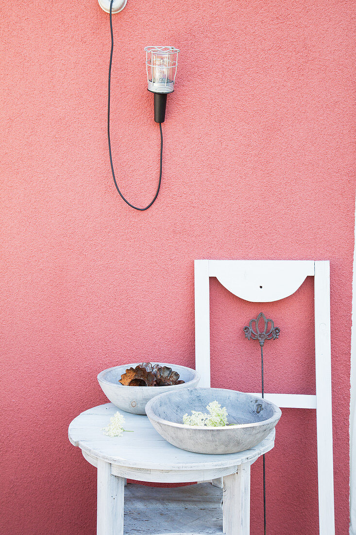 Bowls on table and white window frame against deep pink exterior wall