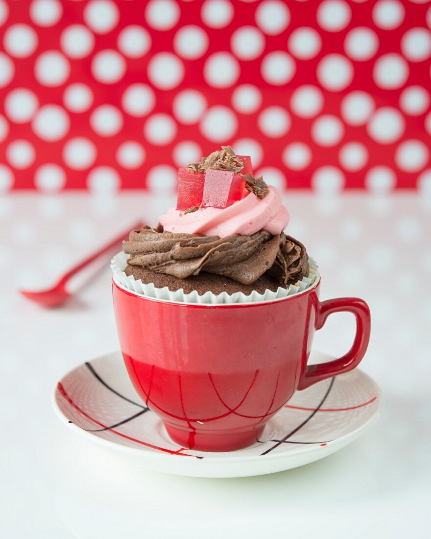 A cupcake with chocolate and raspberry cream and jelly cubes