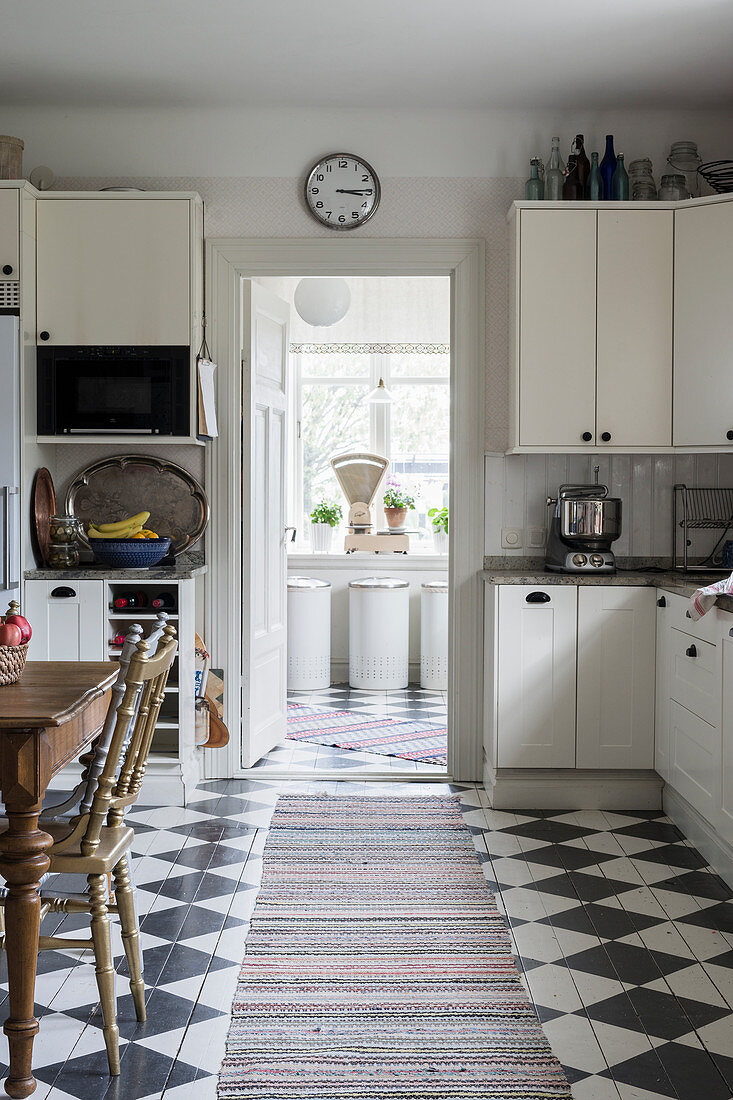 Dining area and chequered floor in white kitchen