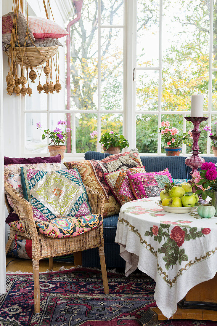 Colourful cushions on seats and round table in conservatory