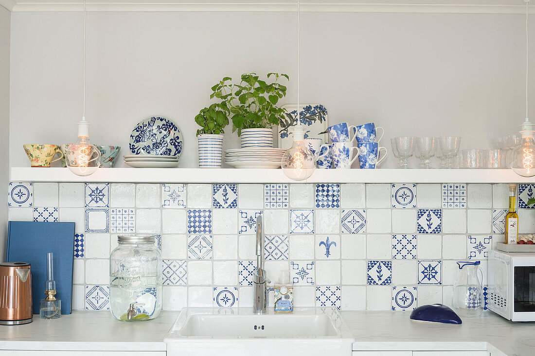 White and blue wall tiles and shelf above sink in kitchen