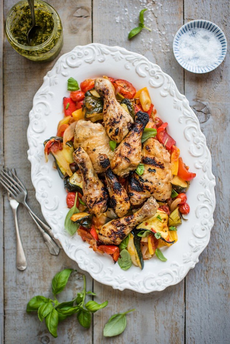 Bbq chicken on a bed of ratatouille with basil pesto