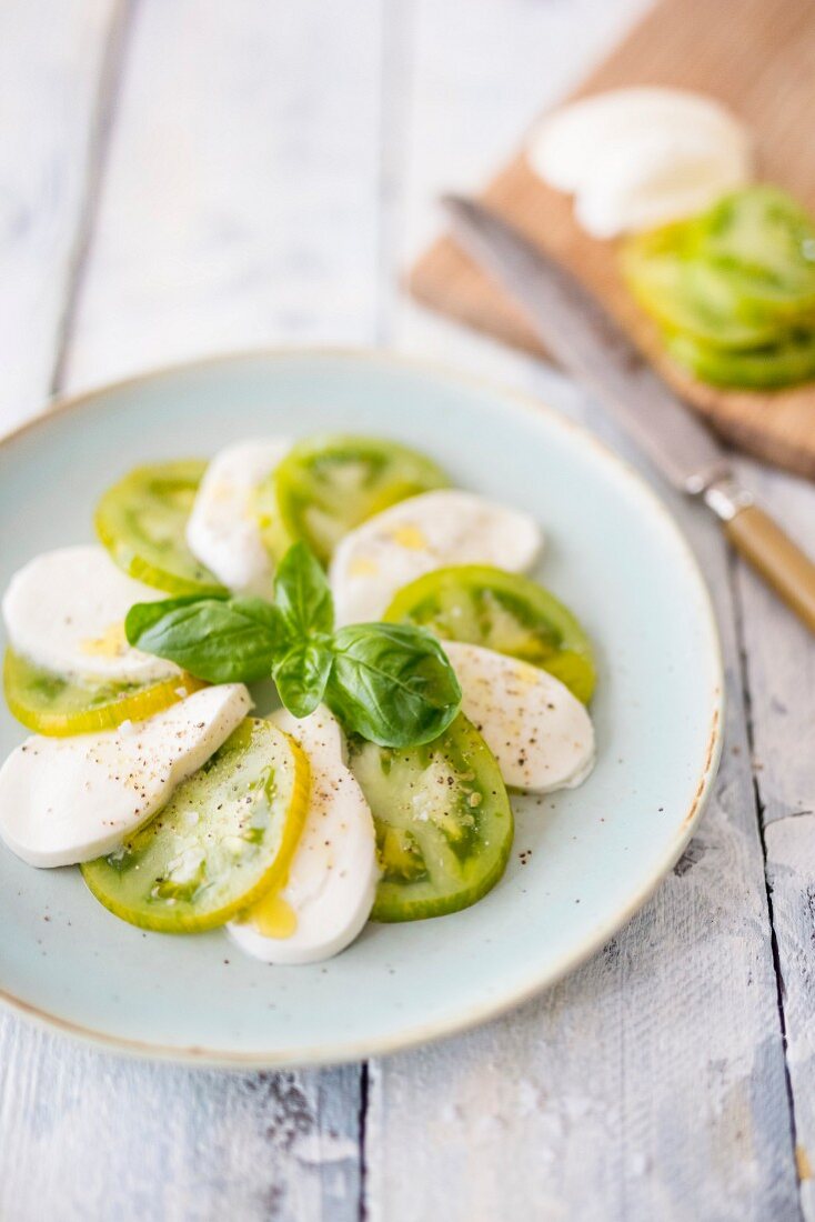 Caprese mit grünen Tomaten und Basilikum