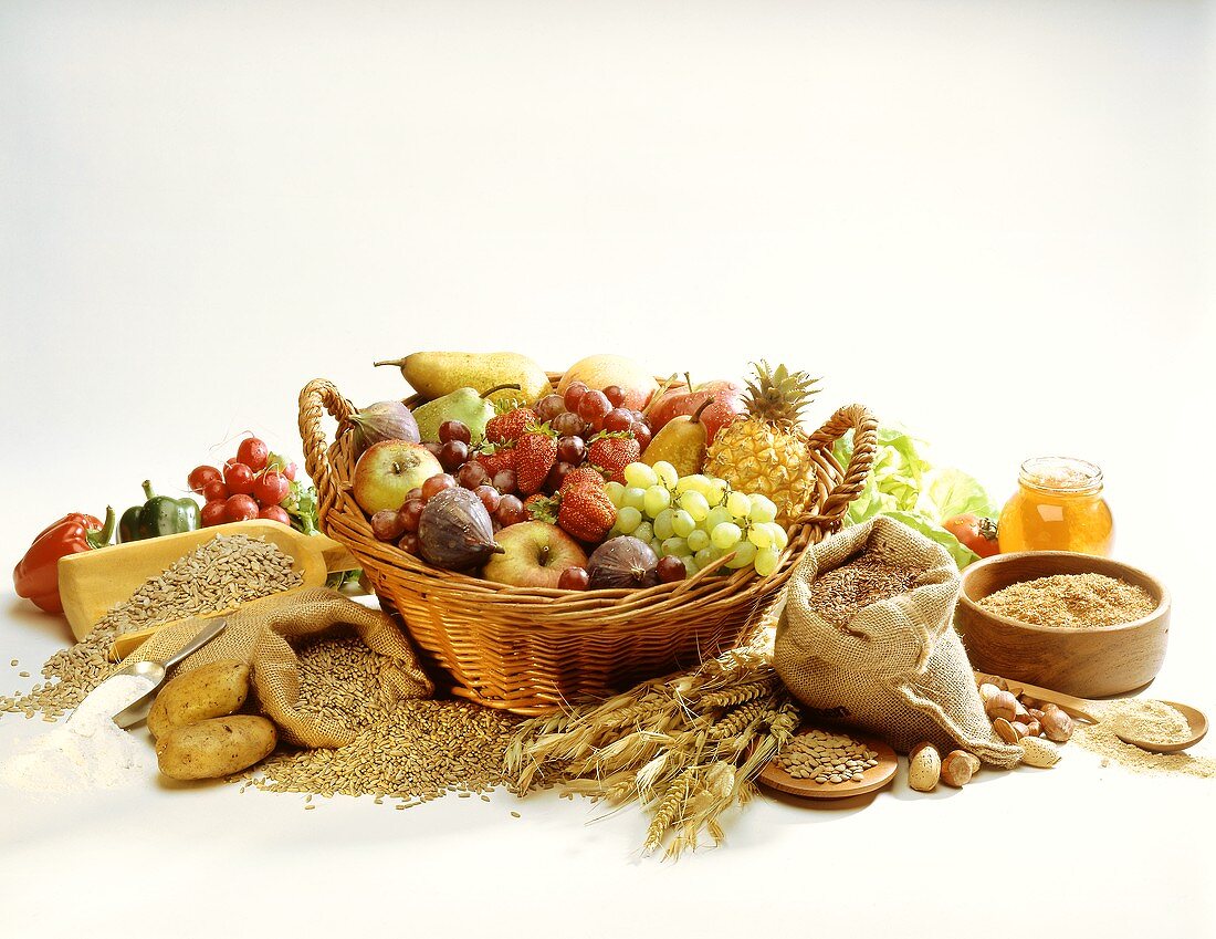 Korb mit Obst & Früchten, daneben Getreide,Gemüse,Nüsse,Honig
