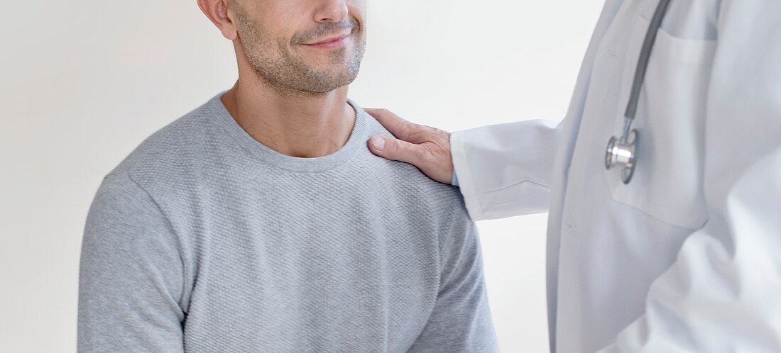 Male doctor with hand on patient's shoulder