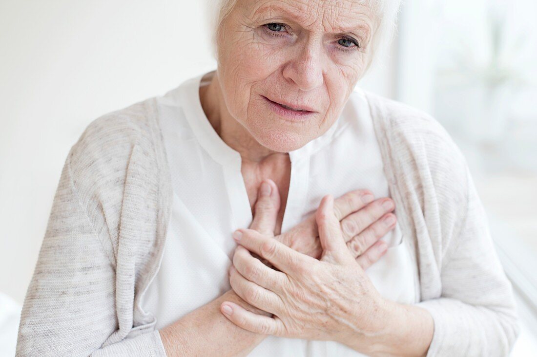 Senior woman holding chest