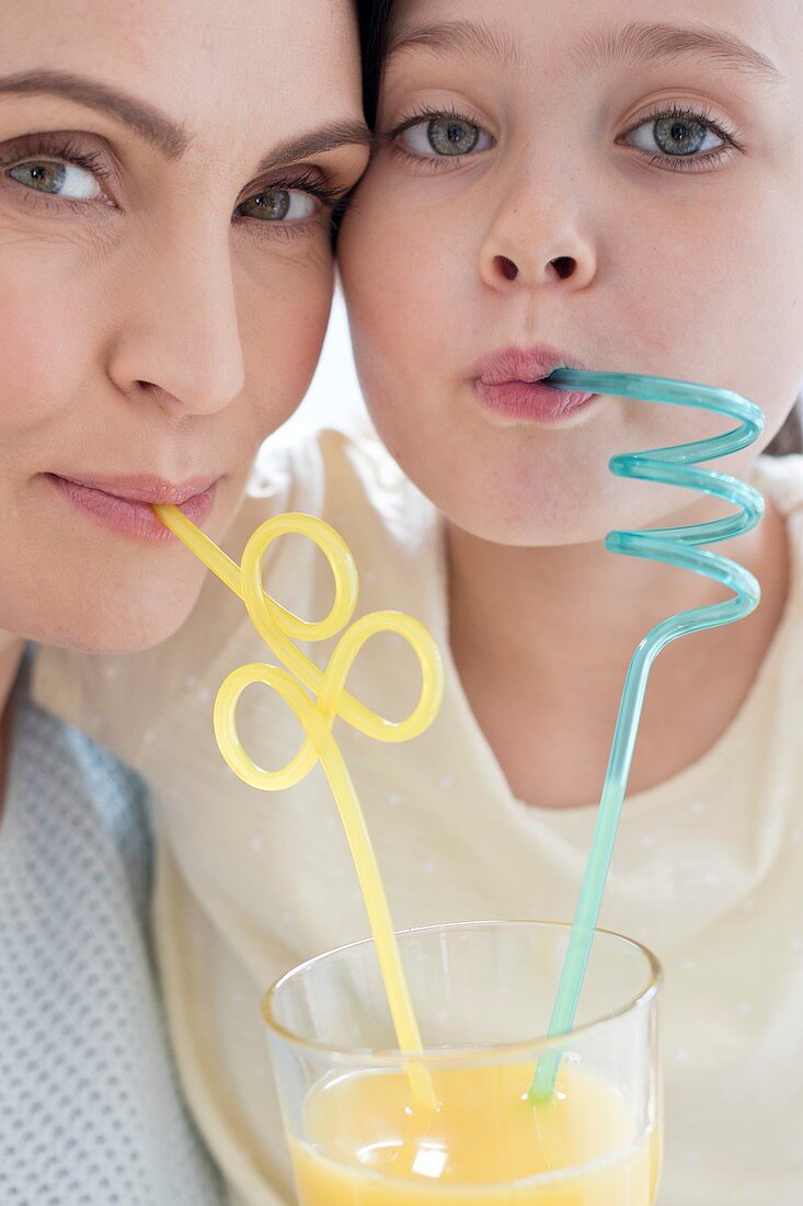 Mother and daughter using straws
