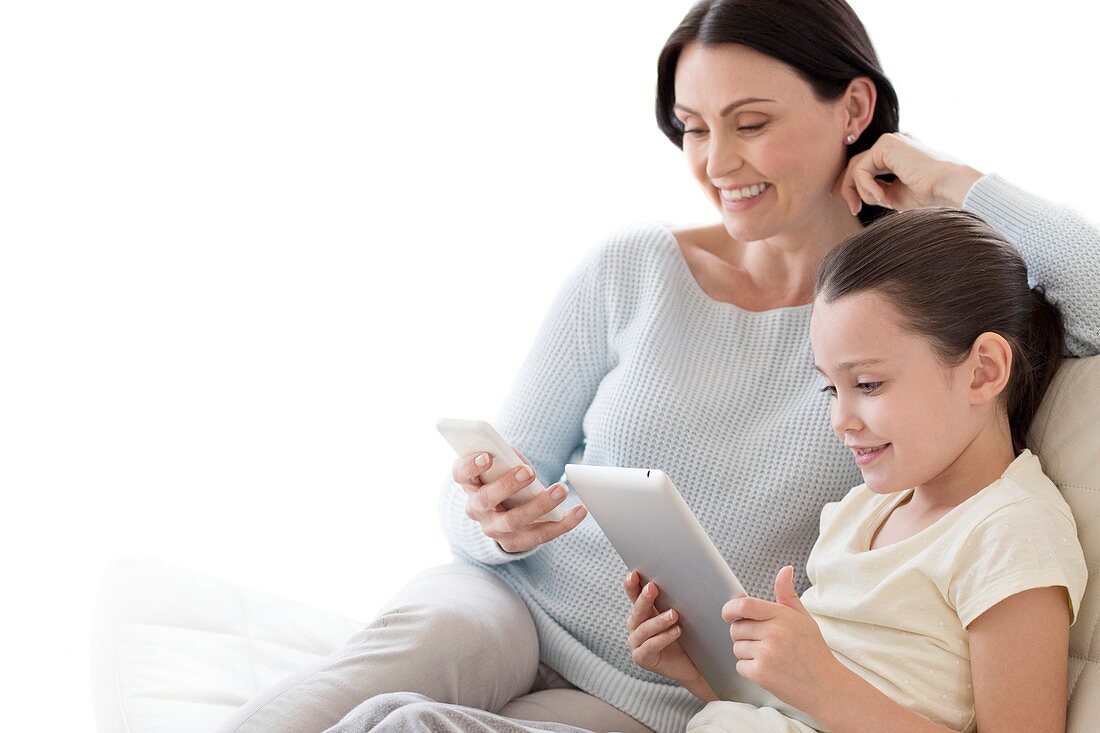 Mother and daughter with tablet and phone