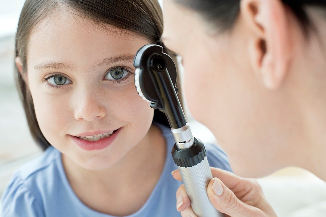 Female doctor examining girl's eye
