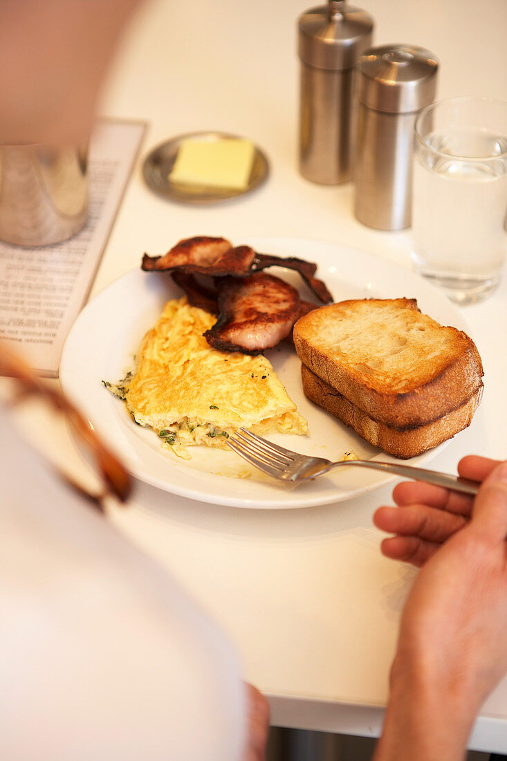 Breakfast with stuffed scrambled eggs, fried meat and toast