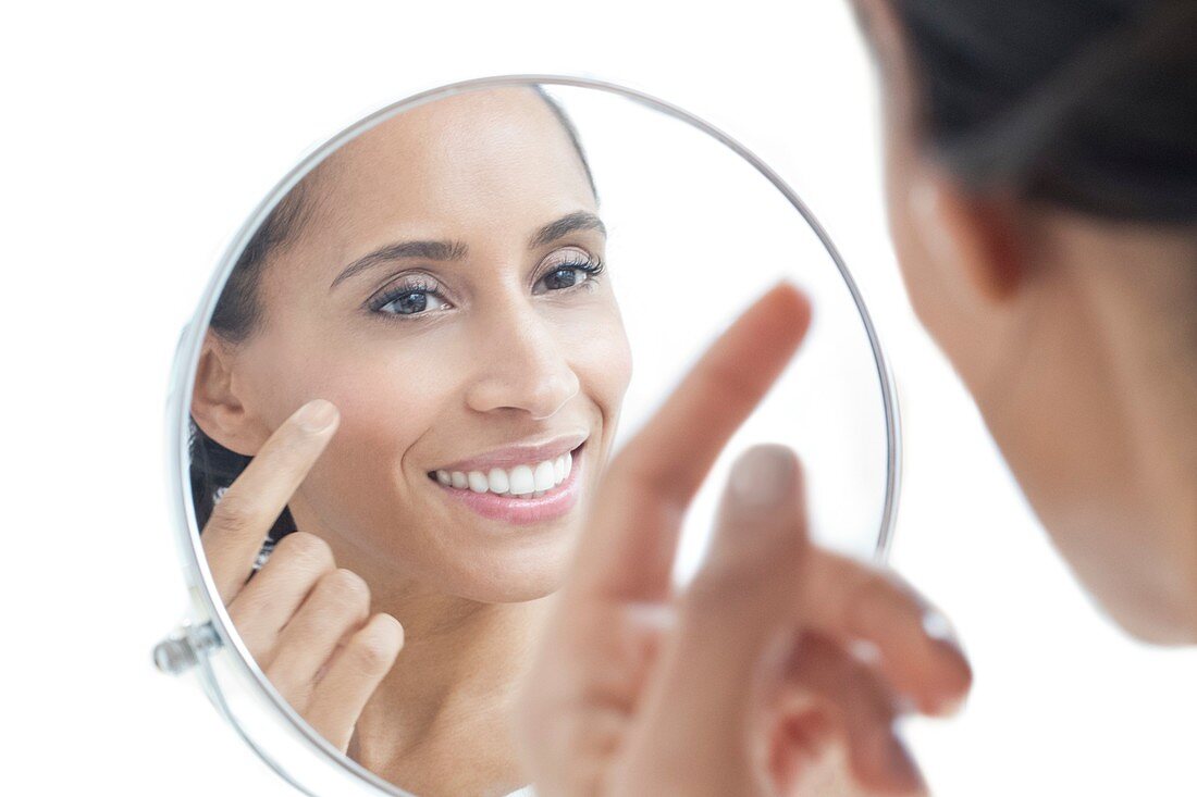 Woman looking in mirror, smiling