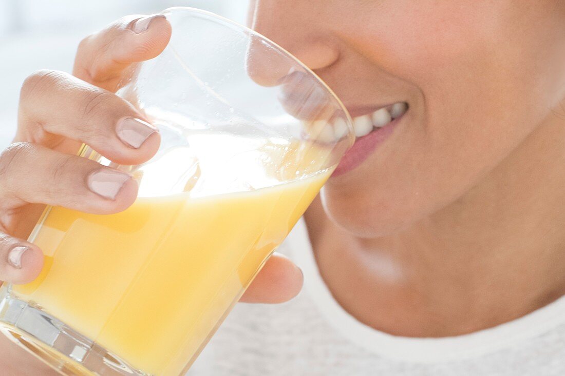 Woman drinking glass of orange juice