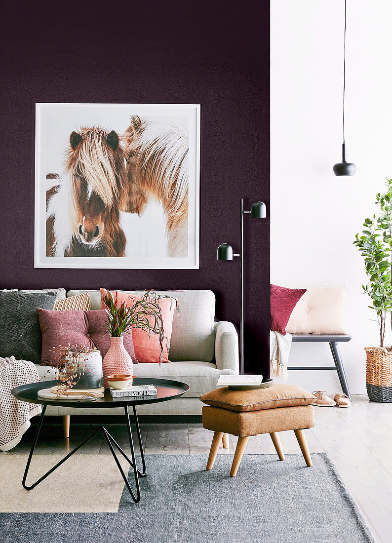 Feminines Wohnzimmer mit Pferdebild an violetter Wand