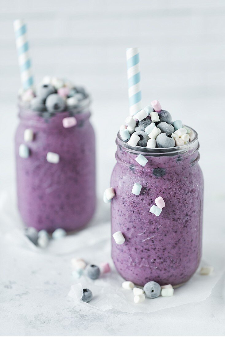 Two glasses of blueberry kefir with marshmallows