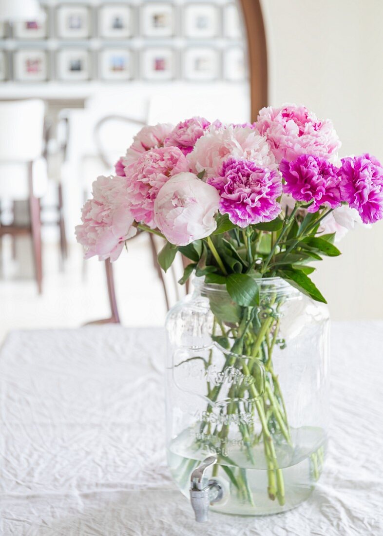 Peonies and carnations in glass jar