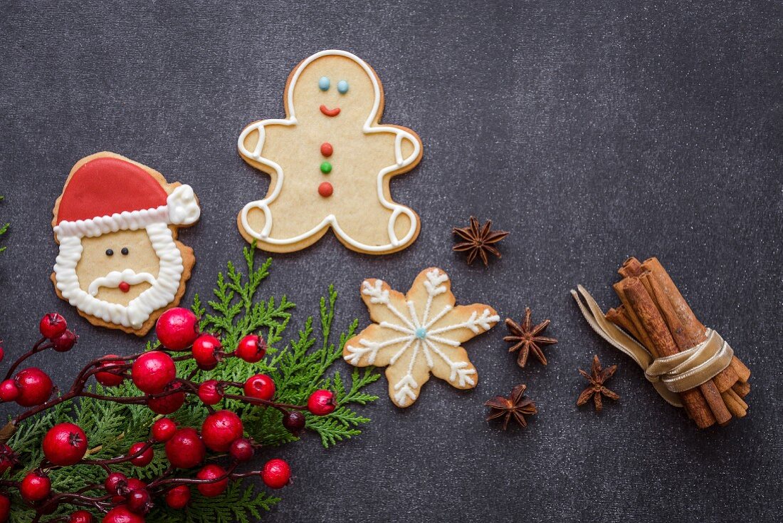 Weihnachtsplätzchen auf Holztisch mit Weihnachtsschmuck und Zimtstangen