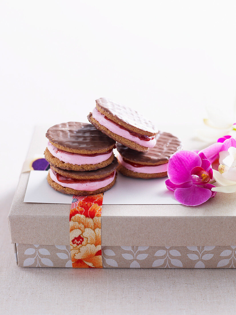 Zimtplätzchen mit rosa Marschmallowcreme und Himbeermarmelade