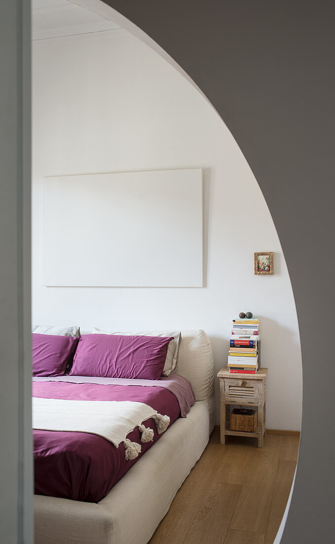 View into bedroom through round open doorway