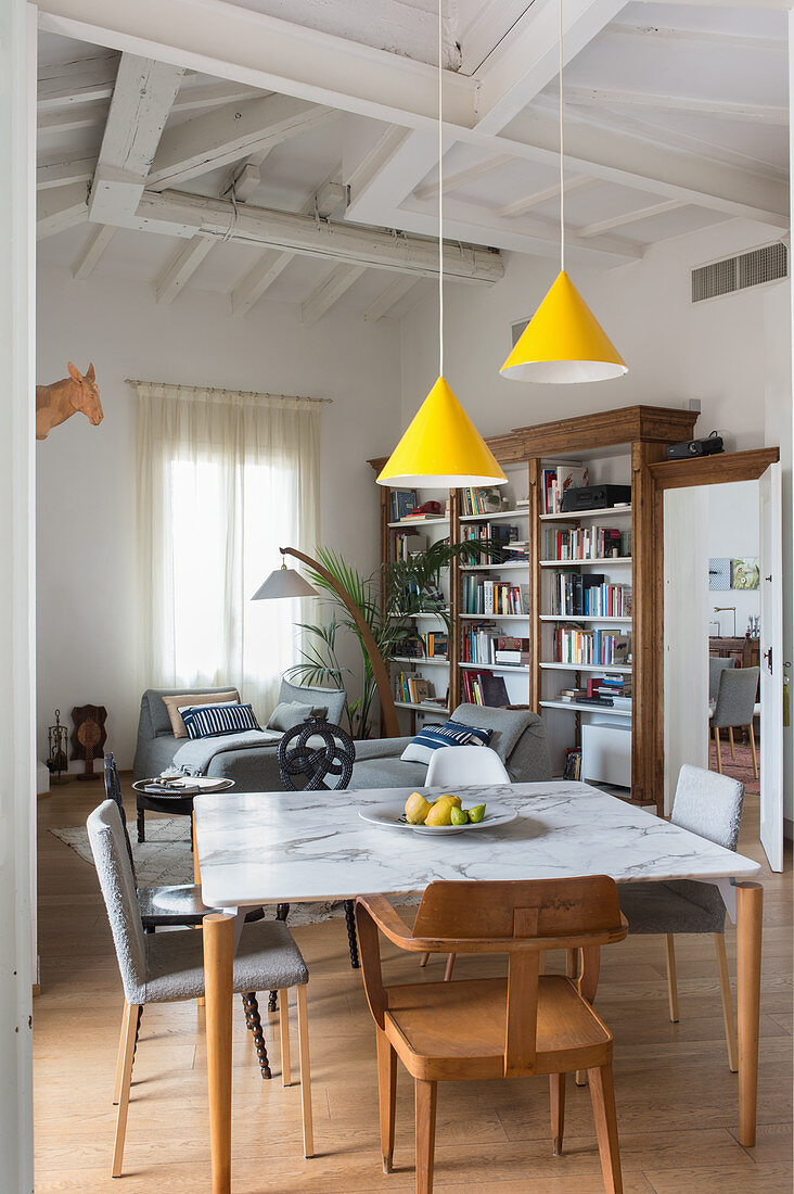 View past dining table with various chairs into living area