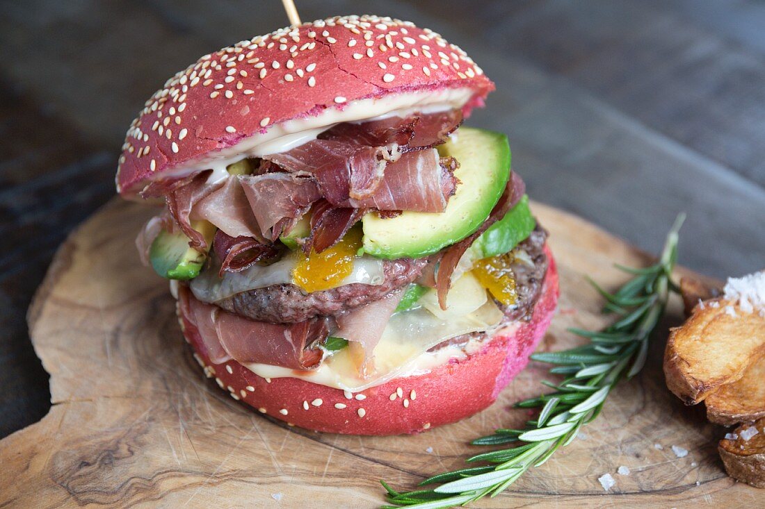 A red burger with beef, ham, avocado, mango and Maltese sauce
