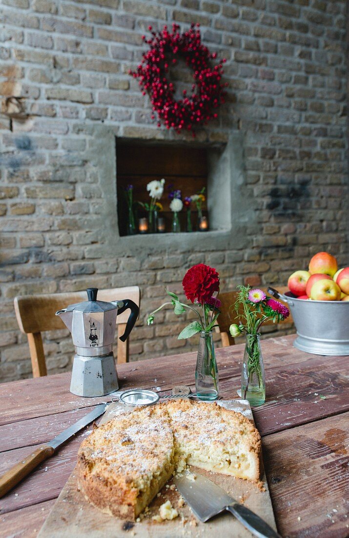 Apple cake and an espresso pot on a rustic wooden table
