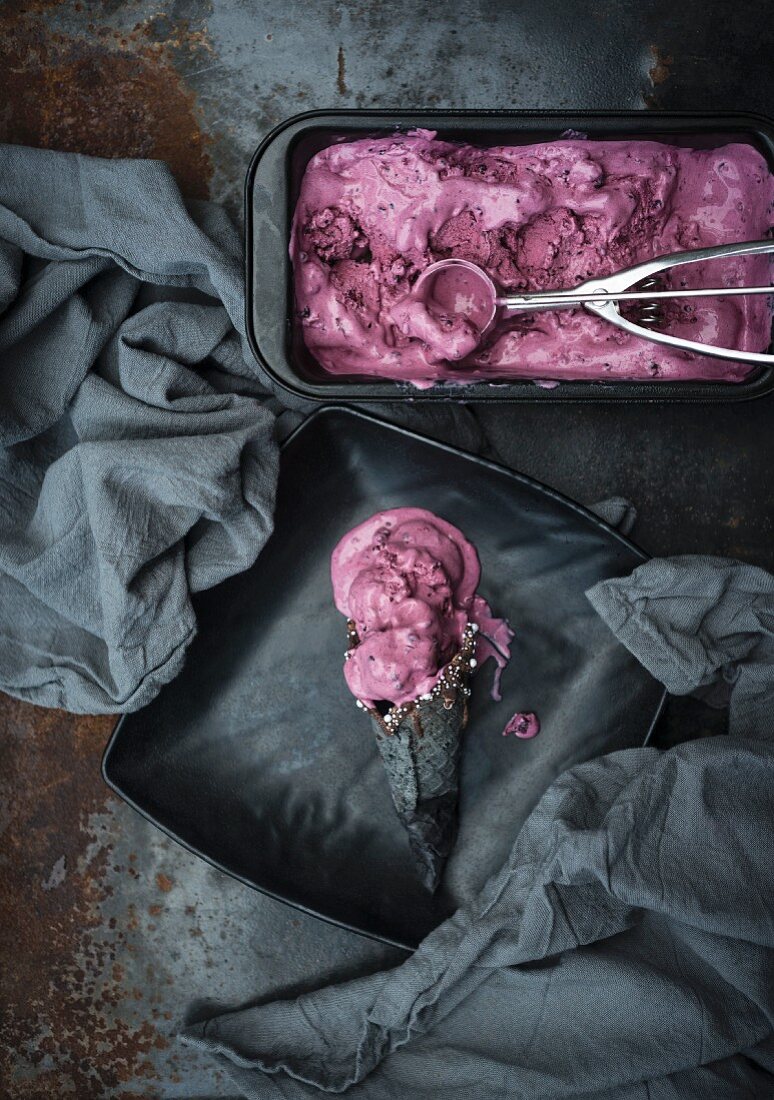 Vegan blackberry and peach ice cream in a black cone