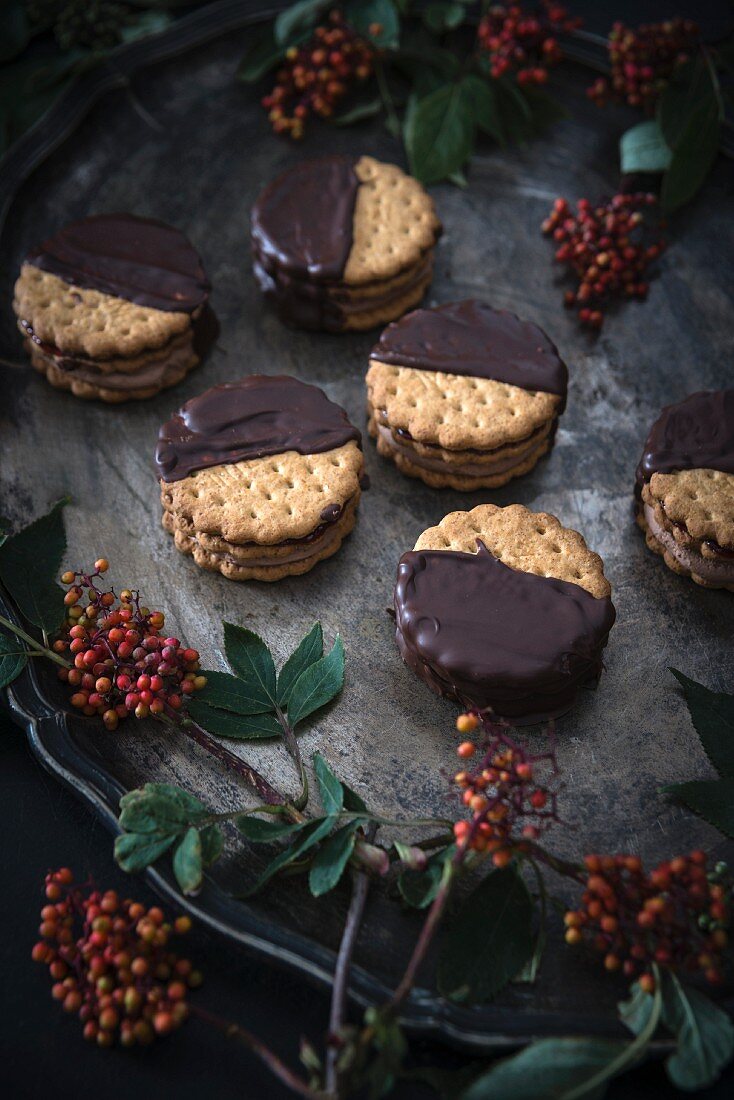 Vegan biscuits dipped in dark chocolate and filled with jam and chocolate cream