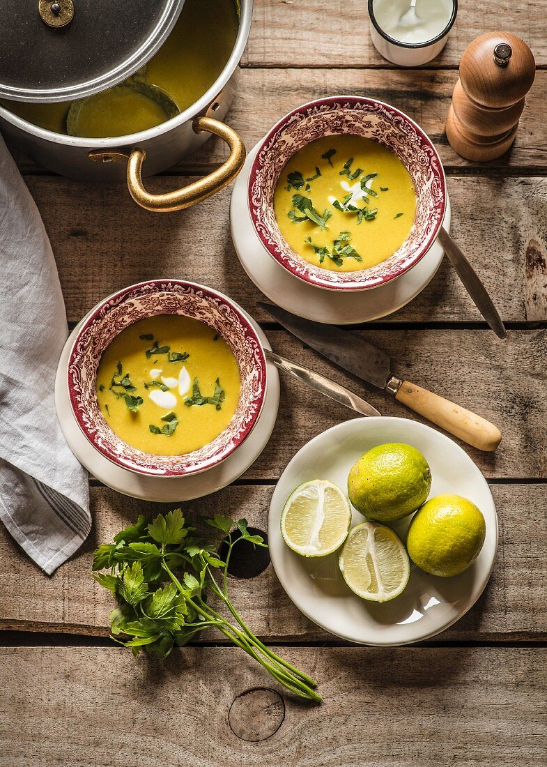 Red lentil soup with lime and coriander on a wooden surface