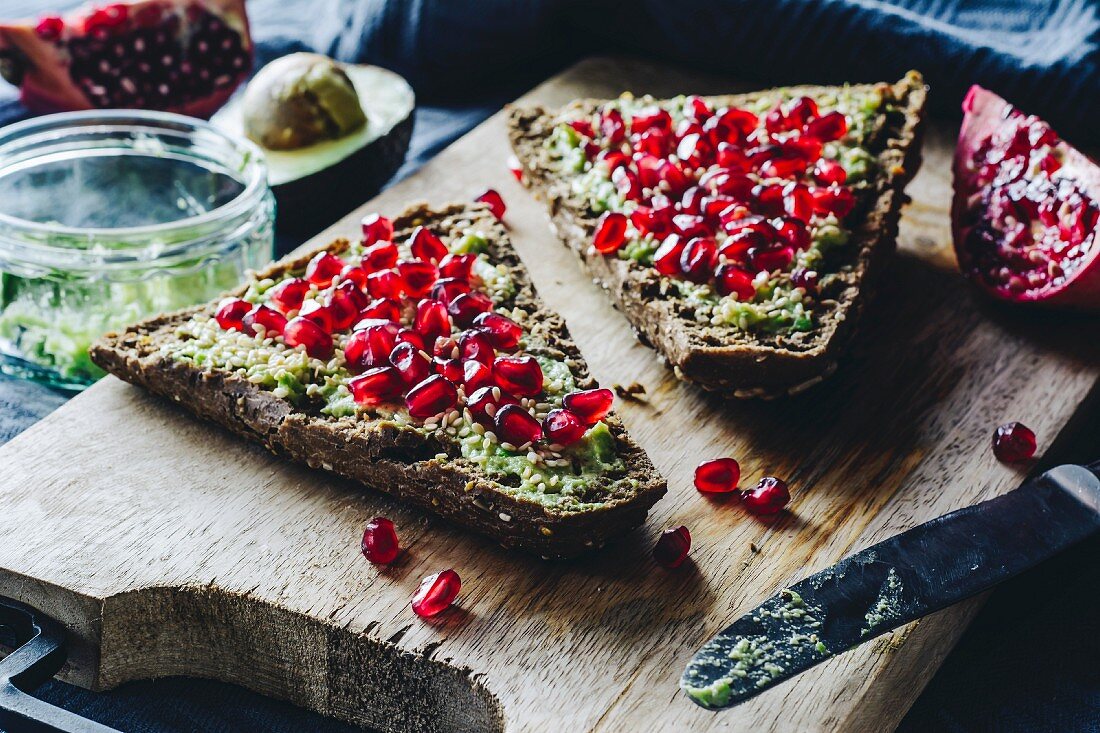 Wholegrain bread topped with avocado, pomegranate seeds and sesame