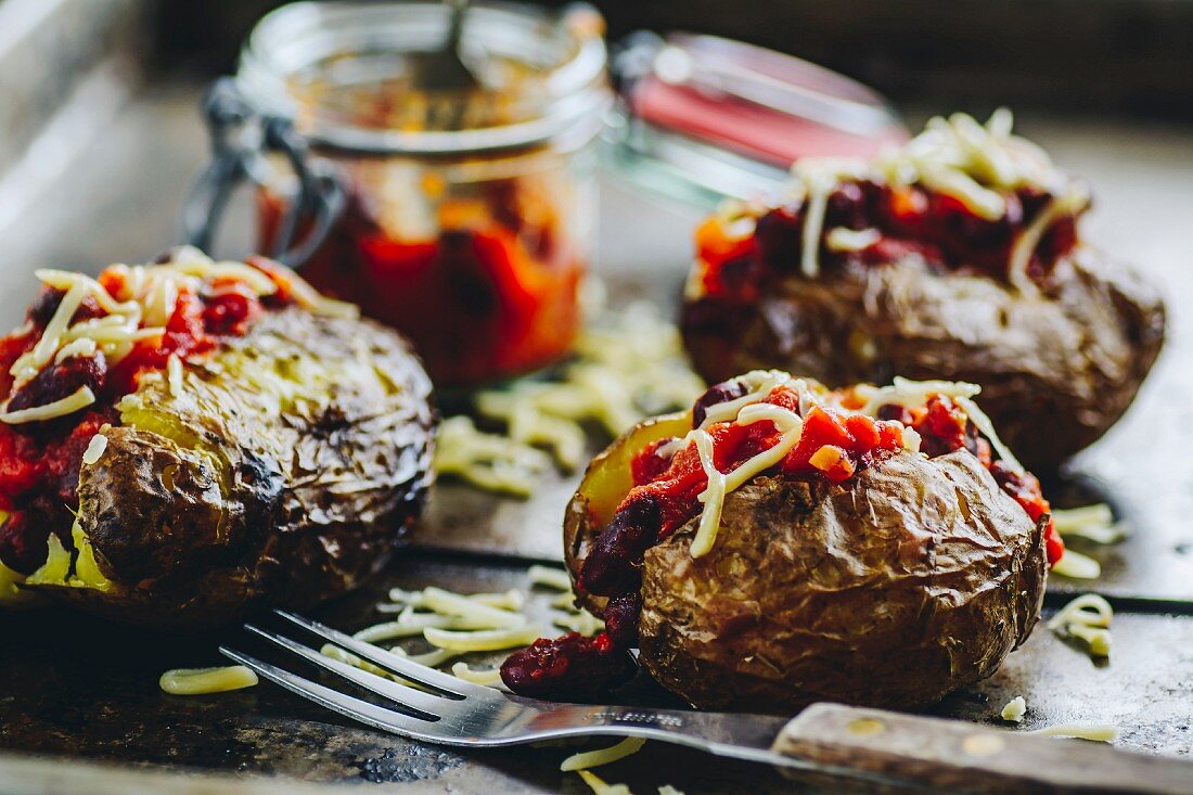 Baked potatoes with chili and grated cheddar