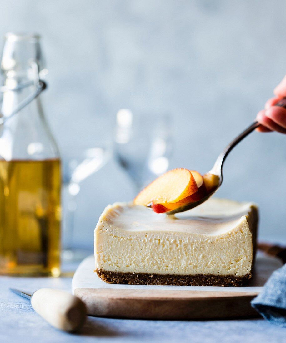 Glutenfreien Cheesecake mit Pfirsichspalten garnieren