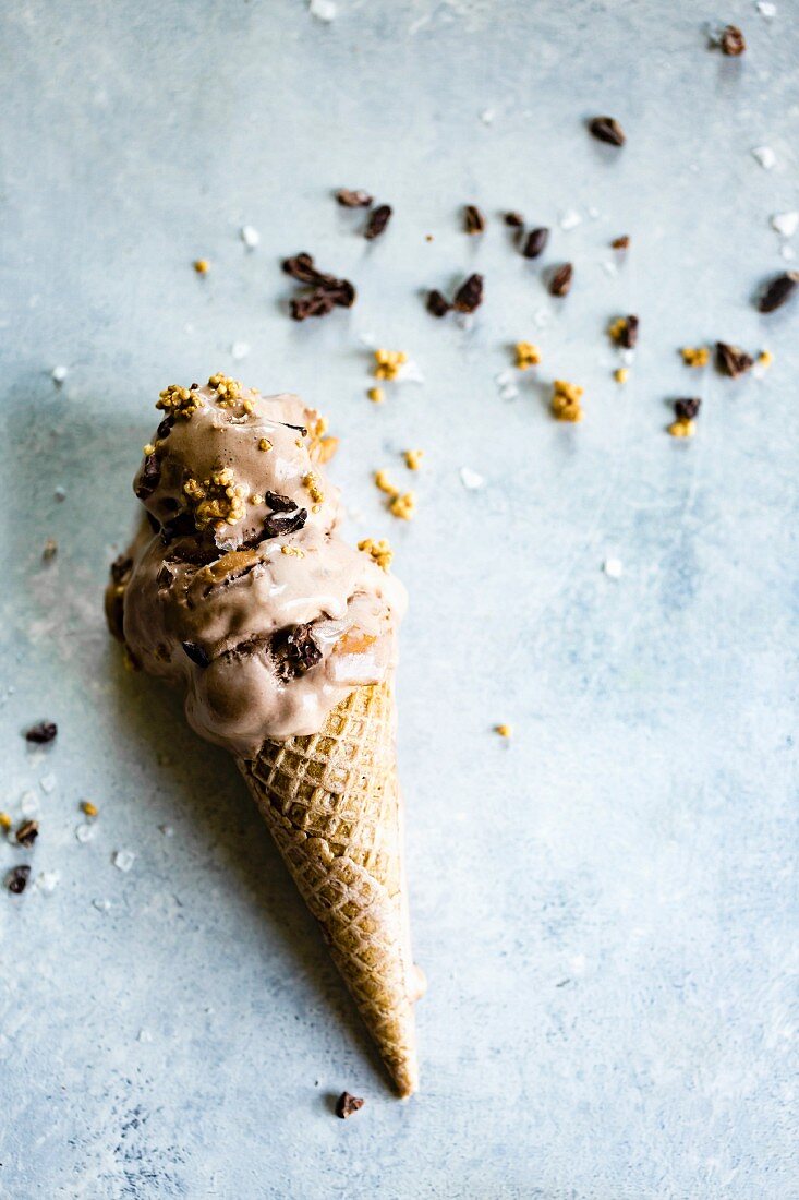 A cone with melting chocolate and peanut butter ice cream