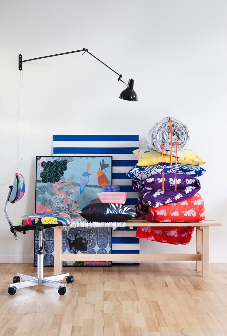 Colourful accessories on wooden bench against white wall