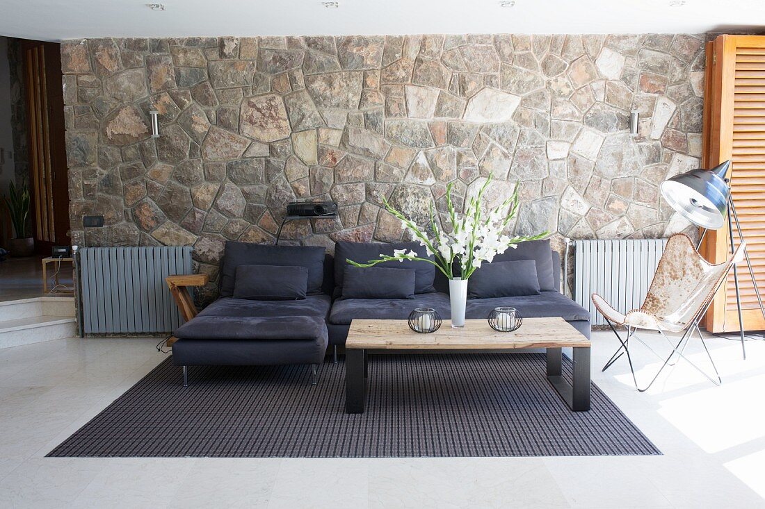 Dark sofa against stone wall