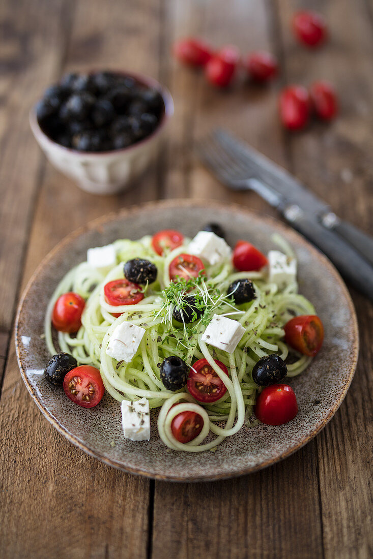 Cucumber spaghetti with feta cheese, olives and tomatoes