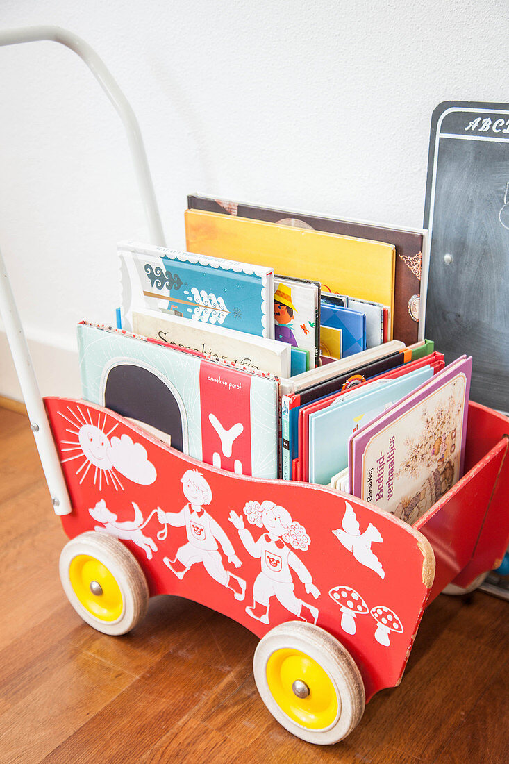 Retro wooden dolls' pram used to hold books