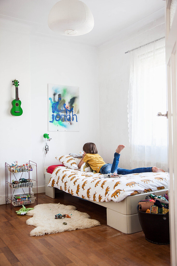 Boy lying on bed in child's bedroom
