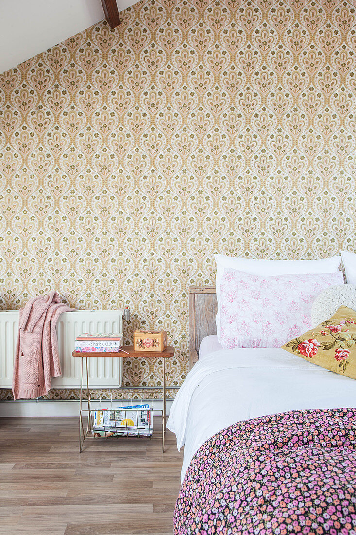 Double bed in attic bedroom with retro wallpaper