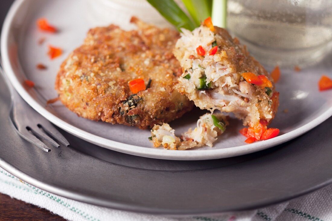 Partially eaten small crab cakes with red pepper